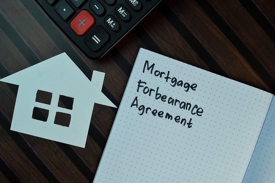 Mortgage Forbearance Agreement write on a book isolated on Wooden Table.
