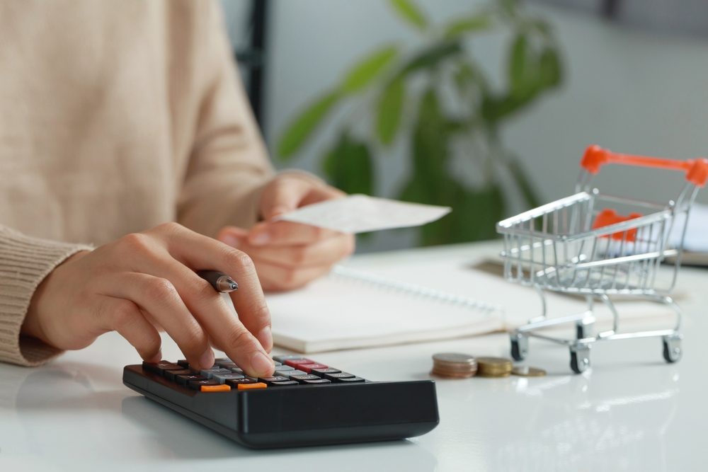 woman budgeting with calculator and notepad