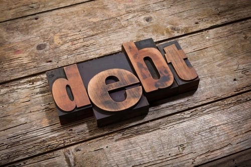 image of word "debt" with wood backdrop