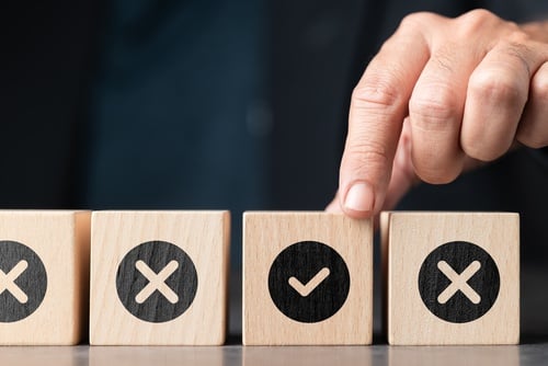 four wooden blocks. one with a check